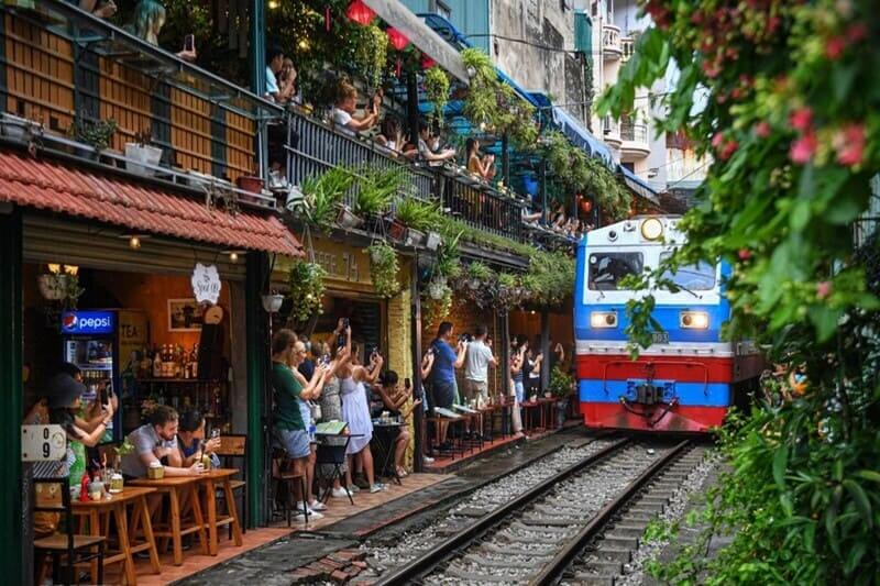 Tourists photographing train on Hanoi Train Street