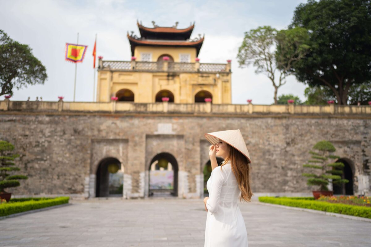 Woman in ao dai at Thang Long Citadel gate